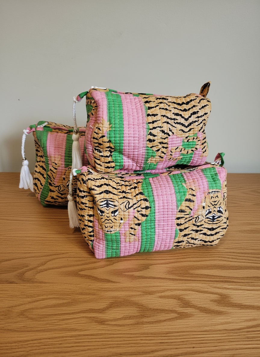 Three cotton vanity bags with tiger print and pink stripes on a white surface.